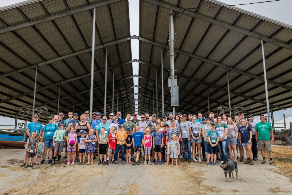 a group of people stand in front of a barn