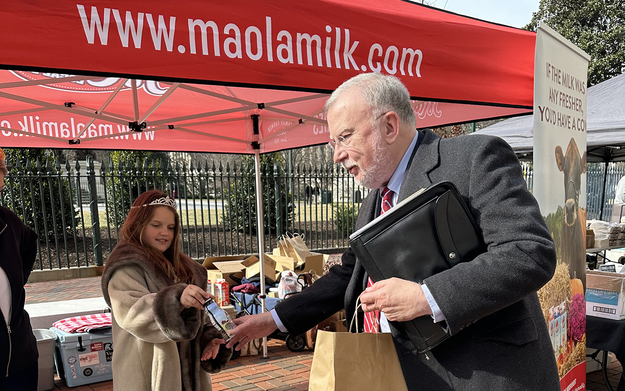child hands man a Maola milk