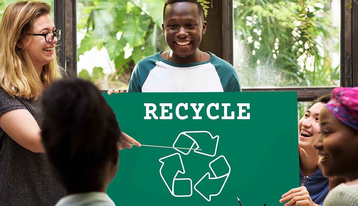 a woman points to a sign that says recycle