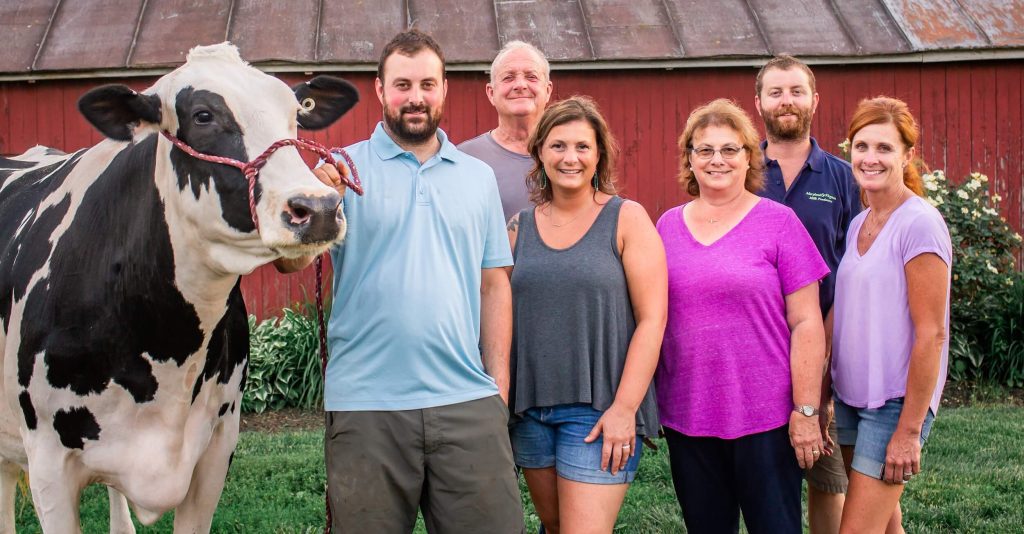 A family and their cow pose together