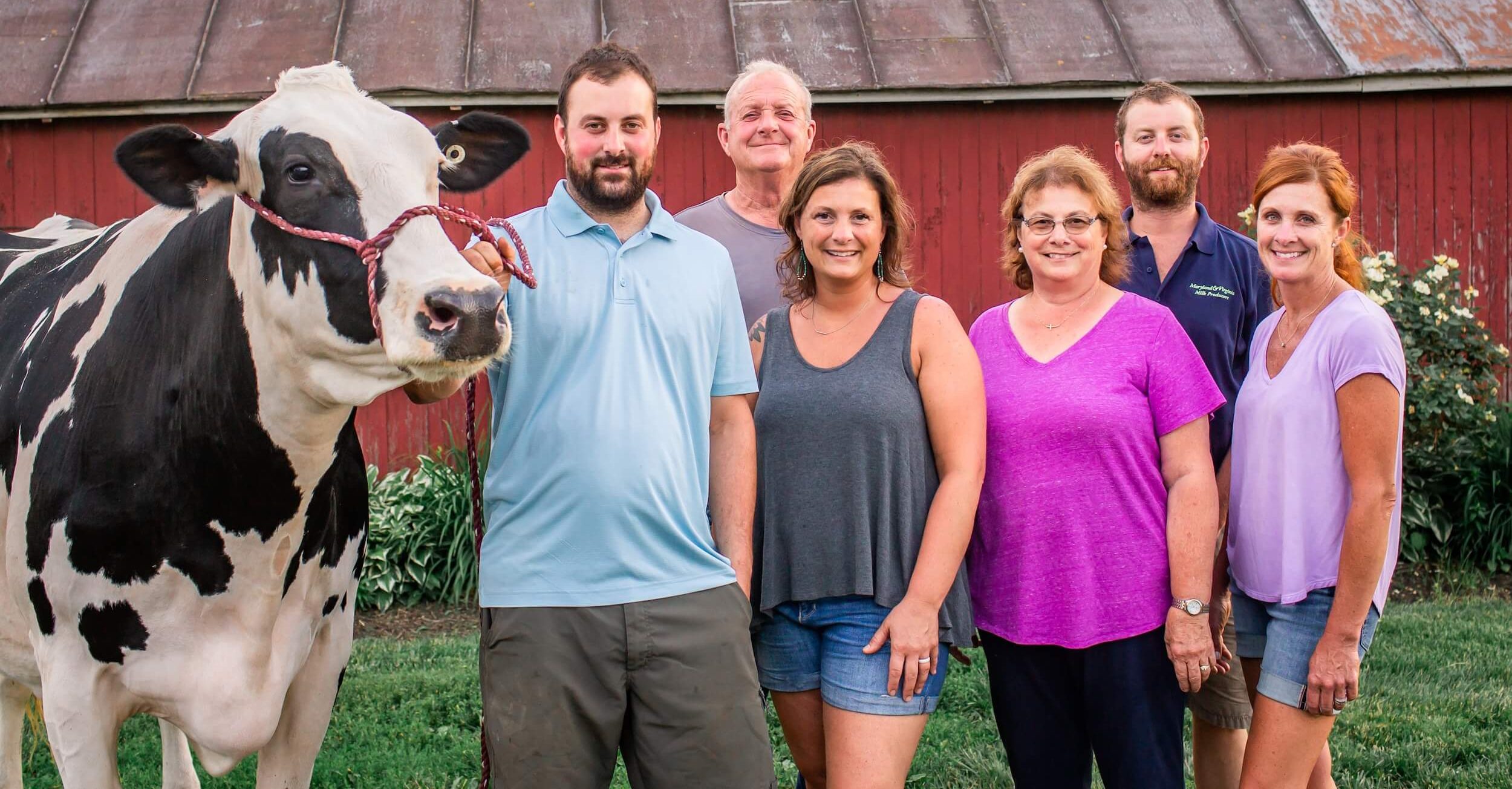 A family and their cow pose together